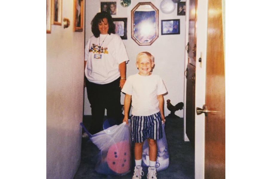 James Hancock as a child holding his belongings in bags.